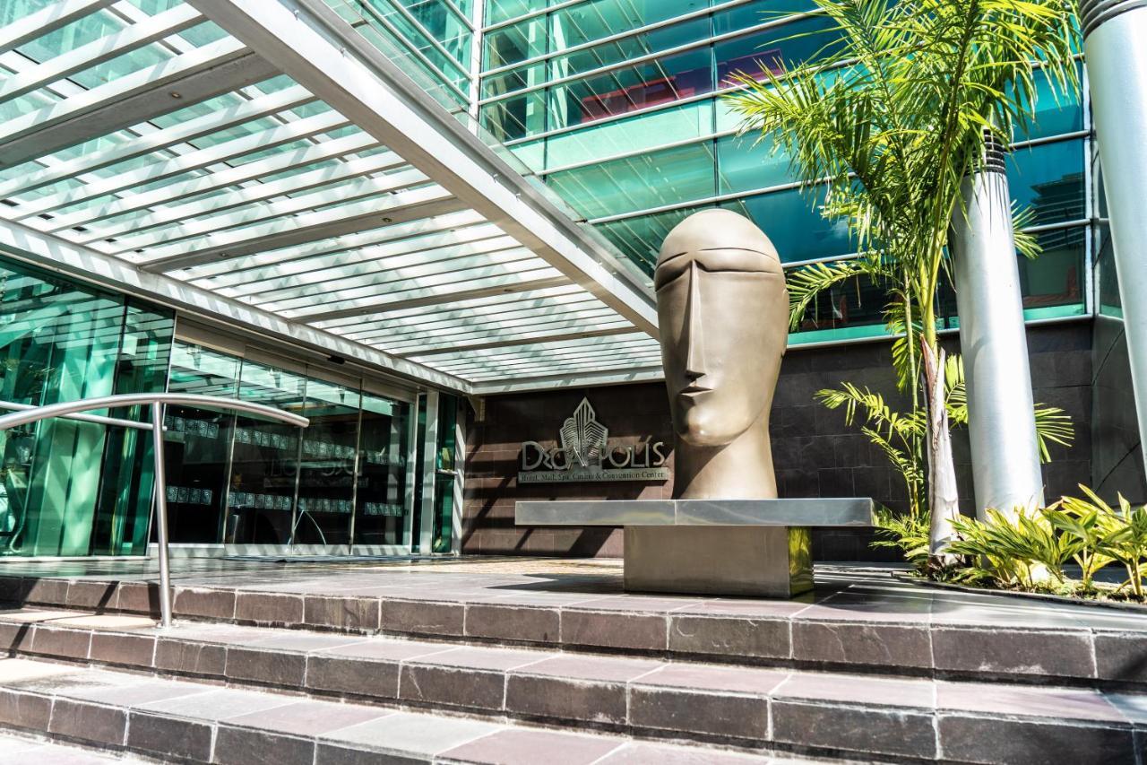 Decapolis Hotel ปานามาซิตี้ ภายนอก รูปภาพ The photo shows a modern architectural setting featuring a large, abstract sculpture of a head positioned on a stone step. The sculpture has a smooth, minimalist design, emphasizing a stylized face. Surrounding the sculpture are glass walls and an ov